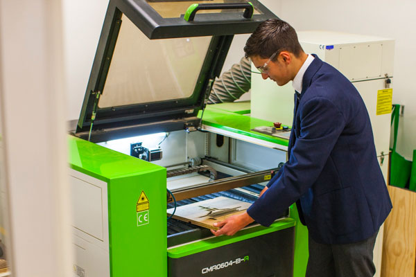 Student taking wood off laser cutter at Clancy Catholic College West Hoxton