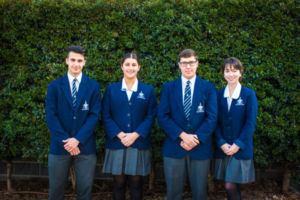 Four Clancy Catholic College West Hoxton students standing and smiling to camera