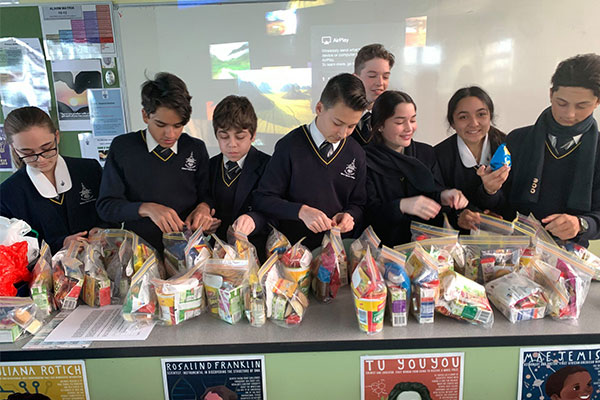 Year 7 and Year 8 students at Clancy Catholic College West Hoxton packing snack packs for Vinnies