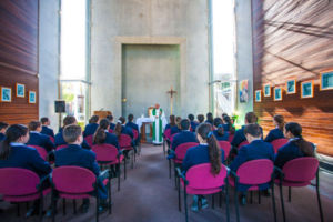 Parish priest leading students at Clancy Catholic College West Hoxton through prayer in school chapel