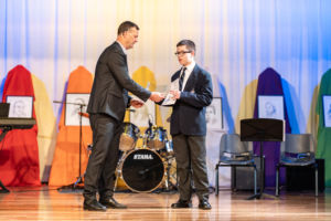 principal with student on stage