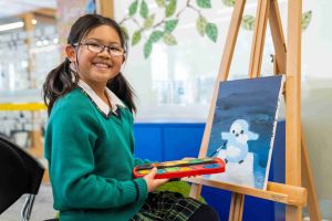 A photo showing a student artist painting